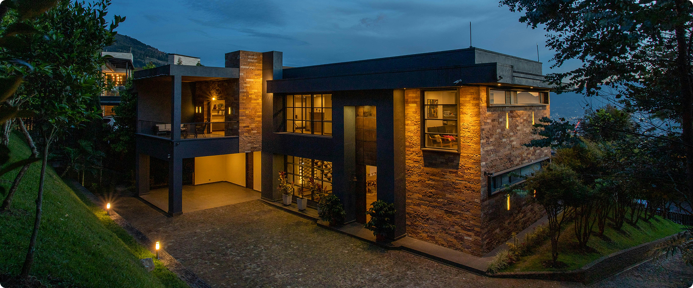 Casa moderna iluminada de noche con jardín
